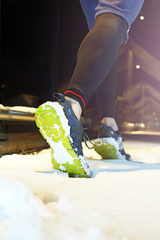 Bieganie zimą.  Bieganie zimą w nocy, buty biegacza w śniegu.