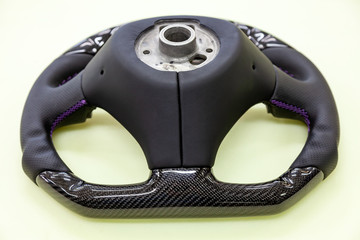 The disassembled steering part before installation of the equipment is a carbon black wheel with...