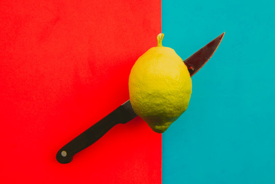 Knife cutting fresh lemon