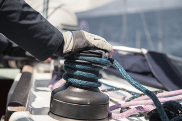  Gloved hand lying on the winch sailing yacht.
