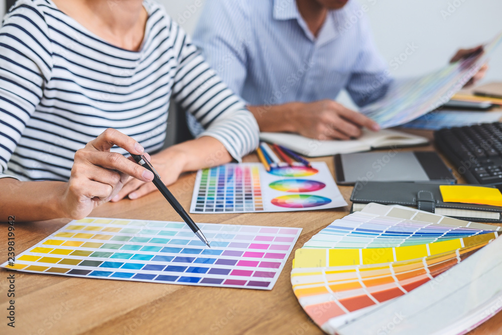 Poster Two colleagues creative graphic designer working on color selection and drawing on graphics tablet at workplace, Color swatch samples chart for selection coloring