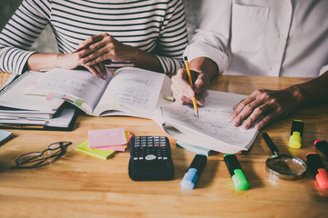 High school or college Asian student group sitting at desk in class studying and reading, doing...