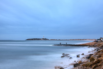 Trafalgar lighthouse at sunset with fishermans in Cadiz