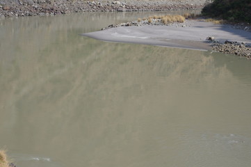 Obraz premium Still brown river water with sandbank