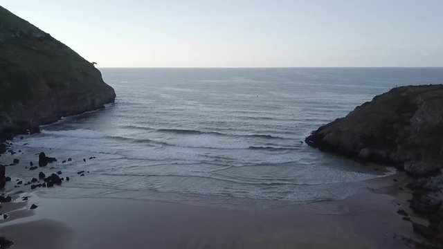 Drone Shot out of a Bay at the Atlantic Ocean. Small waves are running in. Spain Basque