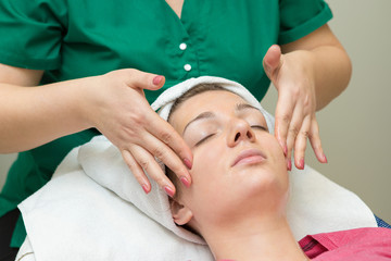 Face skin care. Beautician applying beauty oil mask on face using brush In spa salon