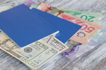 Canadian and American dollars, passports, on the wooden background, blurred background