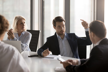 Serious businessmen businesswomen gathered in boardroom discuss new ideas for company growth, discover new ways exploring additional business opportunities solve problems related with small business