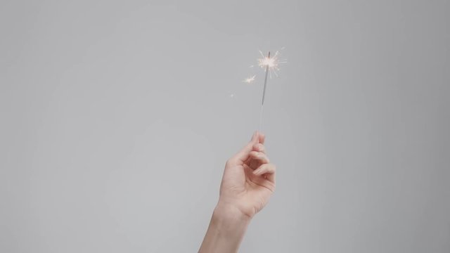 womans hand with bengal lights on syudio background. Minimalistic video 60fps