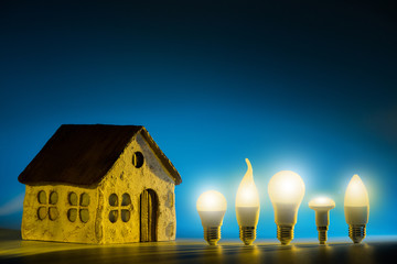 Led lamps stand near the layout of the house on a blue background