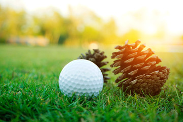 Naklejka premium Blurred golf ball on green in beautiful golf course with sunset. Golf ball close up in golf coures at Thailand
