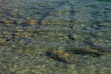 transparent stone rocky bottom of water surface reservoir shoreline background pattern 
