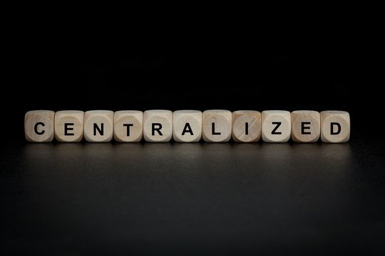 Wooden Cubes With Letters. The Word Centralized Is Displayed. Background Is Black Abstract Illustration