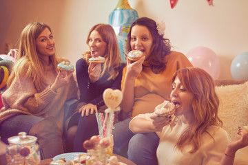Pregnant woman celebrating baby shower party with friends.