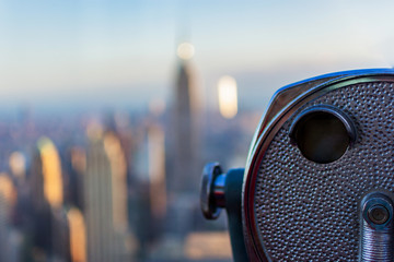 New York city view of binoculars with blurred background of Downtown with Empire state building and  One World trade center 