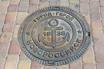 Cast iron manhole cover with the image of the sea anchor and the date of Foundation of the city of Novorossiysk