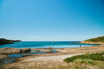 Empty beach in Corsica on sunny day with one ship