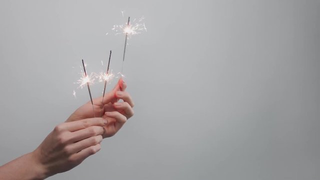 womans hand with bengal lights on syudio background. Minimalistic video 60fps