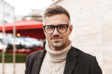 Handsome man wearing a coat walking