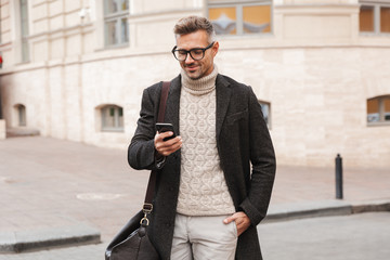 Handsome man wearing a coat walking