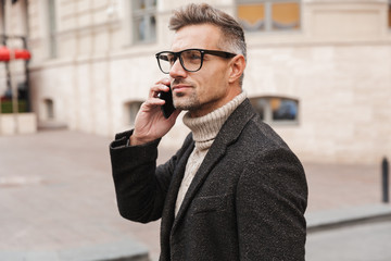 Handsome man wearing a coat walking