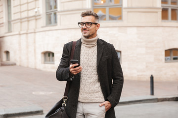 Handsome man wearing a coat walking