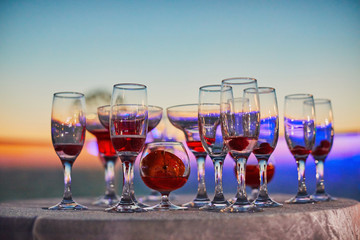 Many different cocktail glasses at sunset sea party
