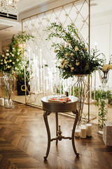 Wedding reception decoration with different electric edison lamps and fresh flowers, rustic style