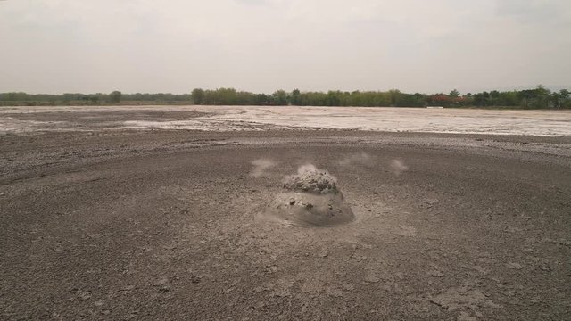 Mud volcano with bursting bubble bledug kuwu, slow motion. aerial view volcanic plateau with geothermal activity and geysers, Indonesia java. aerial view volcanic landscape