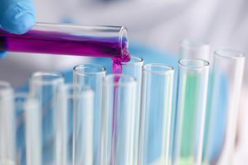 Male chemist holds test tube of glass in hi