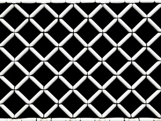White square grid pattern on black wall background.