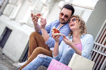 Lovely couple eat pizza outdoors
