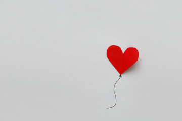 Fototapeta na wymiar Valentines day card. Red paper heart shape balloons on thread. Paper cut style and minimalist concept