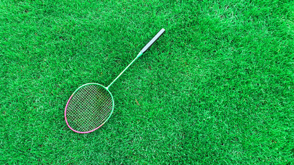 badminton racket on green grass