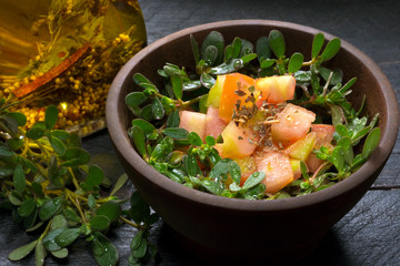 Unusual edible plant called Portulaca oleracea salad in black wood background