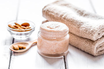 cosmetic set with almond scrub on table background