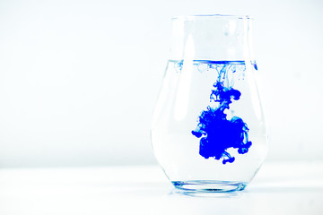 a drop of paint in a jar of water