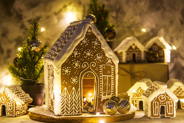 Christmas still life with ginger houses and garland lights on gray background. Homemade Christmas Dessert Concept