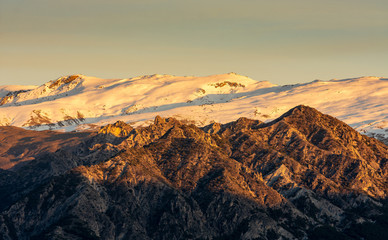Beautiful scenic photo of Sierra Nevada snowcapped mountains during golden hour, Granada