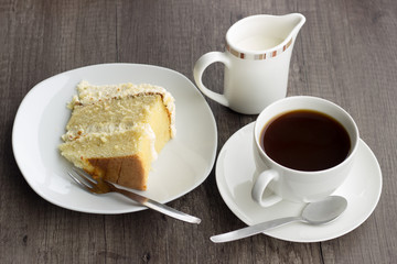 cup of coffee with lemon cake and milk jug