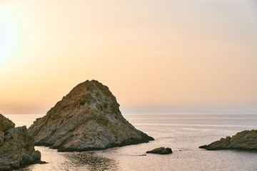 A rock above the sea during great golden sunset colors in Corsica