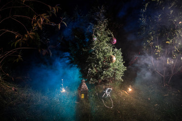 Christmas and New Year decoration on the pine tree branch with lights at the background at night outdoors. Concept of winter holidays.