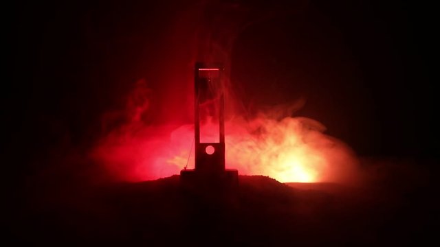 Horror view of Guillotine. Human at guillotine on a dark foggy background. Execution concept