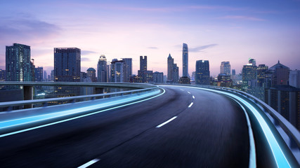 Curvy flyover highway moving forward road with Bangkok cityscape evening scene view . motion blur...