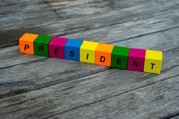 colored wooden cubes with letters. the word president is displayed, abstract illustration