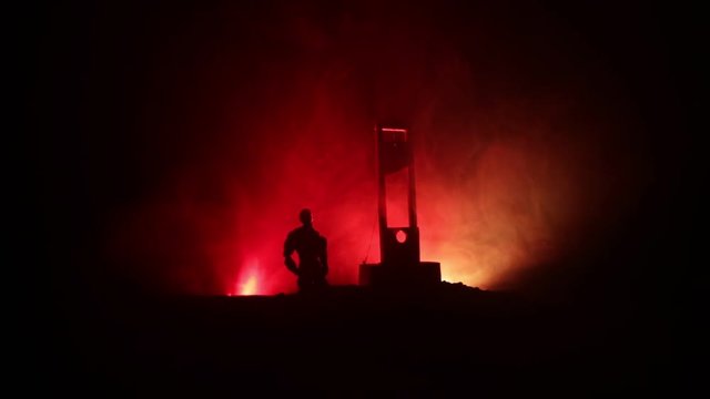 Horror view of Guillotine. Human at guillotine on a dark foggy background. Execution concept