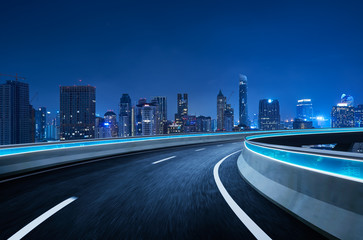 Curvy flyover highway moving forward road with Bangkok cityscape night scene view . motion blur...