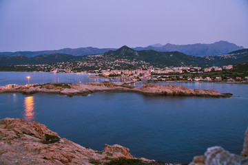 Fototapeta premium City of Ille Rouse in the evening with mountains in the background and sea in the foreground in Corsica