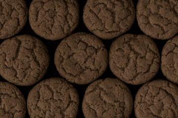 Round cookies on a black background, pattern. Top view.