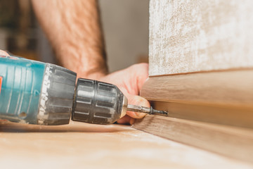Finishing work at home - The master mounts and installs the baseboard to the wall